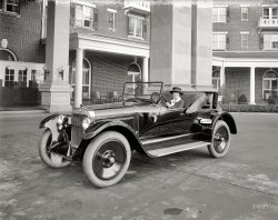 Washington, D.C., 1921. "Mrs. Phil Riley in St. Claire car." (See the comments for more about Mrs. R.) National Photo Company glass negative. View full size.
Early parking lightI was told those side lights were parking lights--required in some urban areas, to be illuminated during darkness, if you parked your car on a public street.
Wills St. ClaireThe car was made by C.H. Wills, who worked for Henry Ford before starting his own company.  Among his accomplishments at Ford were the introduction of vanadium steel in the Model T and the still famous Ford script. Some of his cars featured an overhead cam V8.  
Big carThat looks like an awful lot of car for that little gal. Would love some info about it.
DetailsThe headlight/parking light combo is really cool; and what's that item just in front of her door?  Not as new as it appears, judging by the back edge of the front fender, but it has been detailed to a fare thee well by a Simoniz wizard.  Where was this picture taken?
[That's mud on the fender. - Dave]
I can see the Photographer!And what is that thing on the car next to him, a spotlight?
Wills St. ClaireI was born in Marysville, Michigan because my grandfather was hired away from the Dodge Brothers by C.H. Wills.  The car is a 1921 Wills St. Claire Roadster, the first year they were produced.
GadgetThat is a huge beast of a car. I doubt the lady could see over the bonnet when standing next to it! Does anyone know what the gadget in front of the drivers door might be. A light of some sort perhaps? 
Wills Sainte Claire Auto MuseumLearn more about C. Harold Wills and his Wills Ste. Claire automobiles at the Wills Sainte Claire Auto Museum in Marysville, Michigan, located about an hour outside of Detroit. 
Wardman ParkMrs. Riley appears to be posing in front of the main entrance to the original Wardman Park Hotel, completed in 1918 and razed in the 1980s.
Pretty Snazzy for 1921Mrs. Riley is looking pretty special in front of the Wardman Park Hotel (later the Sheraton Park). Torn down and rebuilt in, I believe the 1970s, and replaced by a much less interesting hotel building. At least Harry Wardman's  Wardman Tower was saved. 
I'd be very happy to have that car today.
What is that ?a light, below the windshield on the side.
Big wheelsI wonder if they called them "dubs" back then. What a machine.
The Mo-lyb-den-um CarAd from 1921 in The Washington Post.
CarcentricI'm curious why so many of the D.C. photos are autocentric.
[Auto enthusiast Herbert French's National Photo Co. counted a number of car manufacturers and dealers among its clients. - Dave]
I think this is my grandmother!My grandparents lived in Woodley Park and were married in 1920. My grandmother later worked at the hotel as a switchboard operator until my father was born in 1924.
The only picture of my grandmother I can immediately put my hands on is attached and was taken when she was about 12 years old. The eyes and nose look very similar to this woman here.
Dave: I would love to have more info about this photo, or know if there are any more, if you can provide.
[What was your grandmother's name? There's another photo here. I've enlarged her face below. Note the man in the window. - Dave]
UPDATE: Grandmother's name was Esther Mildred Maddox Reily (frequently misspelled as Riley of course); she went by "Betty." My grandfather was Philip Joseph "Key" Reily. Thanks for the quick response!
Little gal?I am the modern version of this "little gal" in that I drive a powerful car too: a Chrysler 300C. Since when do you have to be a man to appreciate a fine, Hemi-powered (or any other big motor) car?
Phatsub, what do YOU drive?  I (a little gal) will pit my 5.7L Hemi against whatever is in your driveway ANY day!
The Wills Saint Claire Company and FounderC. Harold Wills Company, the Wills Saint Claire firm, produced some very advanced automobiles, in some ways too advanced. Wills, Henry Ford's first employee, was a bit of a perfectionist. He'd stop the production and make changes as he saw fit. And since his cars would cost far more to produce that his former boss's Model Ts AND with a recession hitting, Wills could not sell enough cars to keep the factory open. To learn more about the car you can contact the museum in Marysville, a friend of mine is the president, Terry Ernest, THE expert on the Wills Saint Claire autos. https://www.facebook.com/pg/Wills-Sainte-Claire-Automobile-Museum-650444... 
(The Gallery, Cars, Trucks, Buses, D.C., Natl Photo)