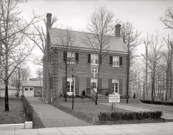 Washington, D.C., circa 1921. "Dunigan houses, 18th Street." Offered for sale by the developer D.J. Dunigan. National Photo Co. glass negative. View full size.
A classicA very nice example of a center-hall Colonial with superb brickwork including some classic quoins. And not your wimpy modern brick veneer, but true brick and block construction I'd wager. Built to last!
Garage LustMan I'd love to have that garage. Just think of the hours I could spend putzing around in there, fixing a vacuum sweeper, soldering up patch cables or changing the water pump on an engine. There's nothing like a detached garage. Watch "Gran Torino" and you'll see why.
That garage means business tooA detached garage in brick and shingles to match the house, a pair of real doors and no foolin'.  
The guy who built this house had a very clear idea of what he was about.
Sad SongOur little dream castle with every dream gone
Is lonely and silent -- the shades are all drawn,
And my heart is heavy as I gaze upon
A cottage for sale. ...
The key's in the mail box, the same as before
But no one is waiting for me anymore
The end of our story is told on the door:
A Cottage for Sale.
 
Larry Conley and Willard Robison, 1929
Where is it now?I google mapped it and wound up at a bus yard in an industrial district.  I hope there is some mistake, like renumbered addresses in the 40's or some such thing. Are there any locals who know where this house might be today?
Jeff
[1321 New York Avenue is the address of the real estate office, not the house. Which, according to the caption, was on 18th Street. So far I haven't been able to find it. - Dave]
Dunigan House NowBased on following article, I checked a little around the neighborhood of 16th St and Longfellow, Kennedy, Jefferson, etc. (18th street doesn't extend this far north).  Found a house in 5200 block of 16th which matches the photo quite closely.  Of course it could be a design that is repeated elsewhere in the neighborhood.



Washington Post, Jan 16, 1921 


$1,000,000 Invested in 70 New Homes
Most of Dunigan Project on Fourteenth Street Already Sold

New homes already representing an outlay of over $1,000,000 have been erected within less than a year on the old White tract now known as Fourteenth Street Highlands, according to an announcement yesterday by D.J. Dunigan, real estate operator, who purchased the tract early last year.
This thriving new subdivision is located on the crest of the hill, at the end of the Fourteenth street car line, and is bounded on the east by Fourteenth street and Colorado avenue.  It is intersected by Longfellow, Kennedy, Jefferson, Ingraham, Hamilton and Thirteenth streets. From this high and healthy area there is a beautiful and comprehensive view of the entire city.  
Mr. Dunigan has already built 70 substantial homes on this tract.  Most of the 70 which he has put on the market have been sold.  Many of these homes are large, with four bedrooms.  Some of them are only two squares from Sixteenth street, where most of the residences range in cost from $20,000 to $60,000.
Mr. Dunigan buys materials in large quantities, and does his own building, thus eliminating many intermediary items of building costs.

View Larger Map
Much like Grandmother&#039;s houseThe general layout, brick construction, raised yard, privet hedges and two-story-plus-attic-and-cellar closely resemble my father's family home in Binghamton, NY, built about the same time or a few years earlier. 
The garage had a turntable that let your rotate the car to avoid backing dowj the long driveway. On the back porch, opening into the kitchen off the drive, there was a small cupboard door opening to the outside for the milkman to use, and I think the original icebox was arranged so the ice man could deposit his block from the outside as well.
These features were long disused when I visited in the 1950s, but my aunts loved to show me the fixings. It was my father's chore as a kid to get up early (which he loathed) to stoke the coal furnace in the basement and get the heat going.
I have a 1929 Hit of the Week recording of "Cottage for Sale," indeed a sentimental little piece.
[My favorite is Nat Cole's version from 1957. - Dave]
Possible Dunigan Homes SpottedGallatin St  &amp; 13th Street NW.  
(The Gallery, D.C., Natl Photo)