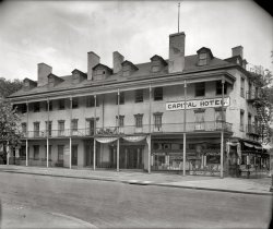 Washington, D.C., circa 1920. "Old Capital Hotel, 3rd and Pennsylvania N.W." When the place was torn down in 1926, the sign had changed from "Capital" to "Capitol." Originally the St. Charles Hotel, it had a colorful (at times appalling) history going back to 1813. National Photo Co. glass negative. View full size.
St. Charles HotelFor most of its long life, this was known as the St. Charles Hotel.  Jesse Holland's 2007 book "Black Men Built the Capitol" notes that ads for this hotel bragged of elaborate "slave pens" in the basement, complete with iron doors, wall rings and chains.  Those pens were a convenience to owners who would come to Washington for its vibrant prewar slave trade.  The hotel's notice promised that, in case of escape, its proprietor would pay the slave's full value.
InflationShave and a haircut, four bits.
Washington slept here... refreshed by good cigars and Coca-Cola.
Love that fontThat druggist's signage (he no doubt did a roaring trade in rubber goods) has a beautiful Art Nouveau font - got to find it, if only for the ampersand!
Coca-ColaHas anyone like me noticed that in almost every old pic, there is a "Coca-Cola" sign?  
(The Gallery, D.C., Natl Photo)