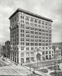 Binghamton, New York, circa 1905. "Security Mutual Life Insurance building." Rising amid a web of wires. Detroit Publishing glass negative. View full size.
With all those gargoylesI feel more secure already.
Did anyone notice that building there?I think Monty Python.
Laurel &amp; Hardy do the WindowsI can't even stand to look at these guys, much less think about doing what they're doing!
Still there!Amazingly, the company and the building are still there. Which is saying something for most upstate NY cities. 
http://www.smlny.com/history.asp
My Home TownThanks for the Binghamton photo! I grew up around this area and love seeing old photos of the place. I'm sorry I never wandered into the lobby of this building.
http://nyslandmarks.com/treasures/10jan.htm
What?No awnings.
VertigoFreaky Coincidence.  Yesterday morning I searched for building using Bing Birdseye View and got the same view as the posting above.  There's the green dome to the right and to the left on the other side of court street is a whitish trapezoidal building, not shown above.
So last night, my wife and I watched the beginning of the 1991 movie "Liebestraum" (with Kim Novak) and about 2 minutes in a man walks out of a shower and across a room to stand in front of a window.  The camera pans left and it's this building!
We didn't watch past that point, we weren't in the mood for a dark, mysterious movie.  And be forewarned, it's pretty explicit up to that point. NSFW or Family.
(The Gallery, DPC)