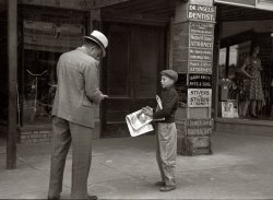 October 1939. Newsboy in Montrose, Colorado. View full size. 35mm nitrate negative by Arthur Rothstein for the Farm Security Administration.
Does anyone know what a Uropractor does?The sign on the bottom of the column reads "Sprog &amp; Sporg Uropractors" I am not sure what that is.  Internet search pulled up nothing. 
[There are no "uropractors" on this sign. No Sprog or Sporg, either. What we have are the Mssrs. Spong, chiropractors. - Dave]

(The Gallery, Arthur Rothstein, Kids)