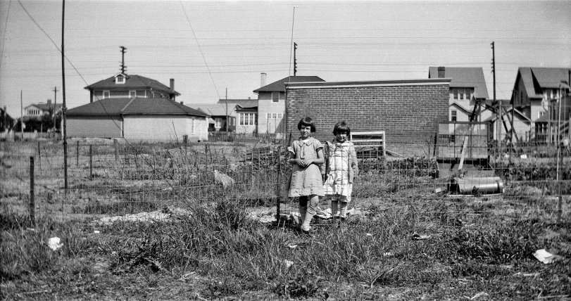 This is my Aunt Florence in her parents' back yard in Burholme, an area in northern Philadelphia. Her father (my grandfather, who died before I was born) built duplex houses independently, lived in one side while renting out the other and moving on to build yet another duplex, often on the same street. Believe it or not, Burholme was semi-rural at the time. It's a bustling part of greater Philly now. The picture was probably taken in the early 1930s.
Aunt Florence was the second youngest of six siblings. (She's the one on this side of the fence. The other little girl would be a neighbor friend.) She was a mischievous, unpredictable child, troublesome at times, but held her own and as a grownup was the mother of three boys, my cousins. During the War she worked in a bomb factory in the city and once had her picture in the paper, posing with her bombs, because she was a good looking young woman. The newspaper caption read, "Beauty and the Bombs."
She was also one of my two "kissing aunts," the other being Aunt Rose, who took this picture. View full size.
