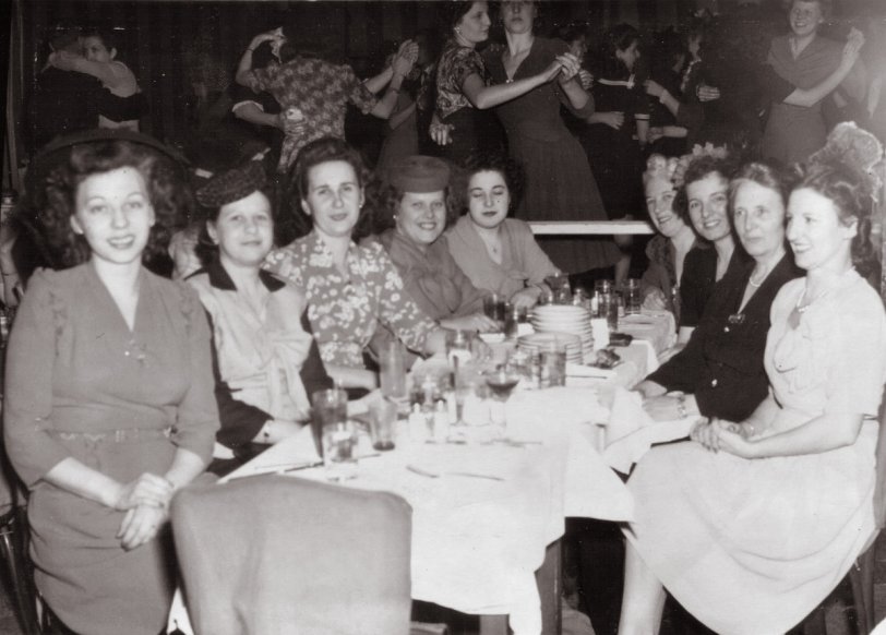 It's December 2, 1944, and my wife's Aunt Vicki, second on the left, and her girl friends (you could call women "girls" back then and get away with it) are celebrating something at the Iceland Restaurant, 1600 Broadway in New York. "Dining - Dancing - 3 Shows Nightly." The absence of men (I see just two on the dance floor) illustrates that about 13 million of them were serving in the military.
I know Aunt Vicki was writing to a sailor somewhere among those 13 million. My guess is the young lady on the left was the reason for the night out -- possibly for an engagement party -- because it appears she has slipped out of the chair closest to the camera to pose so sweetly for the shooter from Planetary Photo, 311 W. 34th St (printed on back of the one dollar photo). Also some of her friends are focusing on her. I'm happy to say today, at 89, Aunt Vicki is thriving in Delaware, has a good sense of humor and a generous nature as great as always. View full size.
