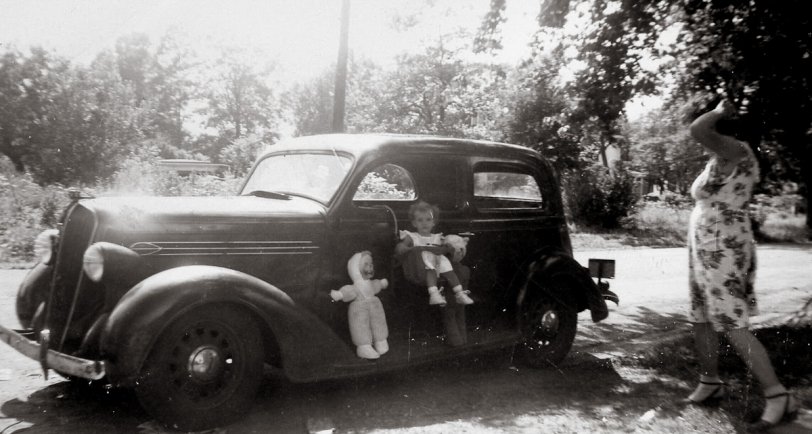 This photograph from the early 1940s was taken in Delanco, NJ. Note that the baby seat, designed just to hang on a car seat, can be hung on the window outside the car. The doll is on the nice-sized running board. View full size.
