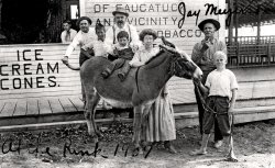 At the new skating rink on Water Street in Saugatuck, Michigan, c. 1909. Saugatuck was and is a historical and picturesque town on Lake Michigan. Jay Myers - man on the right - ran the chain ferry that crossed the Kalamazoo River a few yards away. The burro named Dynamite was a photographic prop. Herman Simonson, who no doubt took this photo, had a studio across the street, a good location to make and sell tourist photos. View full size.