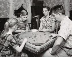 There was a time when people stayed at home and played board games with their family. This photo is from the archives of The Carrom Company that made this game, known as the "Carrom Game Board" or just "Carroms". Many versions of this game were made over the last 100 years in the Ludington, MI, factory, which is still in business. 
This is a Model K board made between 1939-1941. A rulebook that came with all the boards was filled with dozens of different games that could be played on both sides of the board. 
This photo was used for promotional purposes and I would guess it is from the mid to late 1940s. (My family owns The Carrom Company today.) View full size.
Game nights STILL happenWe still have game nights at our home. As a matter of fact, our boys often REQUEST this and they are both in college!
(ShorpyBlog, Member Gallery)