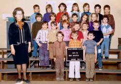 That's me up front, holding the sign and rocking those white pants. Blue Springs, Missouri 1971. View full size.
Class photo clothingAbout half the kids are wearing the kind of clothes kids would wear in the fifties and sixties, and the other half are reflecting contemporary sartorial style: elephant pants, broad stripes, pink and purple (even on the boys), wide belts.  I'm particularly taken by the young chap in the second row, second from the left, with his pants tucked into his tall boots, Cossack-style.
(ShorpyBlog, Member Gallery)