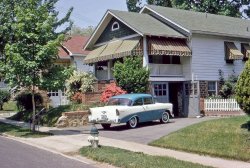 My dad was born in Maryland and lived there until he was 12. In 1964 he and my mother  visited old family friends the Winklers in Silver Spring. This is their house where they stayed, my mother Janice sitting on the front steps. She was pregnant with my sister at the time. View full size.
The photoIs it a print? A 35mm slide? Ektachrome? Kodachrome? Colorized? Sanforized?
RadiusLovely picture, a nice comfortable looking house and a nice V8 150 [right?] coupe in the drive. Getting a car into that clever garage explains the size of the driveway.  Not easy I'm sure, especially late at night or in the snow. Thanks, twaits, for letting us visit.  Can't wait for someone to find a picture of the house today.
Thanks for the correction ----- mulled it over for a bit and just wasn't sure. Glad my fellow Shorpy fans set me straight and glad to see the house is still looking good after all this time!
BTW, wonder why the window in the porch gable was changed.
The PhotoThe picture is a 35mm slide. Dad took all of his pictures back then with a Leica camera and always made the images into slides. This year my sister took a bunch of them and digitized them so they could be viewed on the computer. 
Could this be the place?View Larger Map
That Porch!I could just imagine sitting on that lovely porch sipping a mint julep or iced tea, perhaps during a summer thunderstorm!
Looks like the good folks from Capitol Awning paid a visit there sometime in the past...
https://www.shorpy.com/node/6465
Remarkable!The only thing missing today is the fire hydrant.
Paint jobNote matching car and fire hydrant paint!
1956 Chevy 210Radius, I believe that is a 210 not a 150.
1956 ChevroletThe car still has the snow tires installed on it from the previous Winter season. Either that, or the owner leaves them on all year long.
Change of atmosphereI notice they have bars over the lower right window now, a bit of a shame I think, a sign of modern times... Google streetview certainly doesn't give off the same kind of atmosphere that the photo from 1964 does!
The Silver Spring GalsThe blooming azaleas set the time as late spring.
I wouldn't be surprised to see Nora Roberts or Connie Chung wandering by on their way to attending Montgomery Blair High School.
Goldie Hahn might be heading over to her folks' watch store on Georgia Avenue. 
Gist AvenueMy family lived on Gist Avenue when I was born. When I was very little, I thought all houses looked like the one in the picture.
TiresThe car has the winter snow tires left on it. This was common to leave them on on the spring if they were too warn to make it through another winter anyway. Today many people falsely believe that radial tires are just as good as snow tires and while it is true that they do good in snow they are NOT as good as a real snow tire for winter driving.
&#039;56 Chevy 210 V8The chrome side trim goes all the way back. My mom had a 210 Handyman (two-door station wagon--not a Nomad). Wish I had it today!
bazzilHow did you manage to find that? 
Re: Remarkable!The fire hydrant is still there, just out of the frame that was posted. Looks like they may have moved it over from the edge of the driveway. Probably was backed into on more than one occasion.
Snow tiresin the summertime?  Car's in great shape for an 8-year-old.
Shades vs. A/C1964, all windows and the porch are shaded to keep heat out of the house while having the windows open for a little breeze.  Today, no shades because most dwellings are equipped with air conditioning.  I wonder if the current residents realize that keeping the shades would render a lower summer utility bill?  Apparently not.
[Awnings are a huge maintenance hassle, especially in places that get snow. - Dave]
Where Dad grew upThis is the house my Dad, William Winter, grew up in until he was 12. He just sent me the following to share. His best friend was Jackie Evans back then. Perhaps some of the Evanses still live in the area.
"Jacky (John Wilfred Evans) I think lived @ 127 Gist.  Had a sister Joan and another that I can't remember the name.  Tommy Day lived a couple streets away.  His dad was head of the bank of Silver Spring in the forties. Carlista just called and said Jacky's other sister was (Ginny) Virginia."
View Larger Map
Two more picturesHere's a couple more views. Note these do not have the awning. My parents went to DC in the Spring of '64 so they must have just been getting ready for summer. That would also explain why someone noticed snow tires still on the Chevy. (although I have no idea how anyone could tell this from the picture!) 
One last picture of Gist Ave.There's a sign on the right hand side of the street that says "Hardware C.S. Youngblo..." Youngblood? The sign actually might be on the side of a van parked in a driveway. When I first saw it I thought it was on the lawn of a house. 
Snow TiresIt seems the snow tires were on the rear only. Cool car; my mom had a green '56 Chevy 110 two door around the same time but in Burbank, CA.
Reminds me of grandma&#039;s &quot;56&quot;My grandmother bought a brand new blue and white '56 just like the one in your photo from Luby Chevrolet in Baltimore, Md.; she drove it till 1968
(ShorpyBlog, Member Gallery)