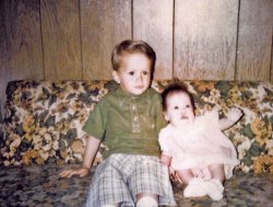 My sister and me in Spring, 1970. Fountain, Colorado. I am four years old and sure, while I was styling in the early 70s style, I still cringe at the short pants and that green shirt - almost as much as I cringe about the couch we are sitting on and the wood paneling of my grandmother's home. 
My mother took the image using her Kodak Instamatic 104 using Kodak 126 film she dropped off at a Fotomat on US 85/87 in Security. I am sure a flashcube was needed - it was inside, although I suppose sunlight could have penetrated Grandma's heavy curtains. 
My sister was born with a double cleft lip and palate. Her first of 40 corrective surgeries will come within a year. View full size.
(ShorpyBlog, Member Gallery)