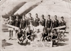 I believe that one of these men was an uncle of one of my parents. It was likely taken during WWI. These guys appear to be extremely physically fit and I'm sure they acquitted themselves well in their service. View full size.
Battle FleetThe Battle Fleet (later Battle Force) was part of the Navy's organization from 1922 to 1941.  If this was not taken on the West Virginia (BB-48) then perhaps it was on another ship that was hosting the All Navy competition.
http://en.wikipedia.org/wiki/Battle_Fleet
ACR West VirginiaThat's the Armored Cruiser West Virginia,  not the battleship.  The proof is not so much the caliber of the barrel but their length, although those are not 14" guns.   ACR West Virginia had 8" guns,  which were Battleship size just ten years earlier than her design.   But all of the Pennsylvana class cruisers had relatively short barrels and an open foredeck while the Colorado class Battleships had a much longer barrel as it was standardized length,  but would need to be long enough to superfire over the last A turret  when mounted in a B turret.   Addtionally,  Colorado's didn't have the open foredeck, they had a gunwale that would have been obvious in this picture,  as it would be where the sailors are arrayed. 
However,  that does mean this is NOT a World War I photo,  but one taken shortly before the war,  say 1916ish.
Probably the Second USS West VirginiaThe first ship of this name was an armored cruiser, renamed the USS Huntington in 1916.  The battleship West Virginia was commissioned in December 1923.  The guns behind the sailors appear to be much too large for an AC.  The photo probably was taken on the battleship in the late 1920s.
(ShorpyBlog, Member Gallery)