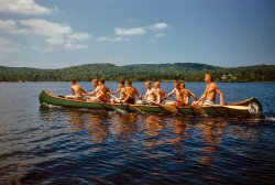 July 1955. "Art Brooks and boys canoeing on Little Lake Sunapee, New Hampshire." 35mm Kodachrome by Toni Frissell for the Sports Illustrated assignment "Boys' Camp." View full size.
War canoeI can't quite guess the length, but that's a beautiful "war canoe" to carry that many kids.  I've got an 18-foot Old Town "High Water" from 1929, and it's really only good for about four people, and those on the light side.  I'm guessing at least 25 feet here.  Looks like the counselor has taught them how to paddle properly, too.  He's clearly the king of the J-stroke back there.
The other thought I have is "hope they know how to swim," because skinny boys like that don't float well in the case that the canoe tips.  I remind my skinny sons of that often!
[Like yours, this canoe looks to be about 18 feet long -- at most. - Dave]
Maybe.  What I also know, though, is that my canoe rides pretty low in the water when loaded with about, I'd guess, two thirds of the weight in that canoe.  So if it's only 18 feet long, it's wide.
Band CampLake Sunapee is where quintessential American rockers Aerosmith got their start, and where frontman Steven Tyler still maintains a summer home on the lake to this day. Rock on Shorpyites!!
https://steventylerdotcom.tripod.com/interviews/steven99.html
Out of curiosityThe canoe length discussion prompted a quick photo mensuration exercise. Using IrfanView, I measured the pixel length of the canoe and the pixel length of one of the younger boys (seated, half-height). I assumed he was about 12 years old with average full height of 54 inches and used the lower end of recent height tables to account for shorter humans about 70 years ago. Using different half-height points for humans, this proportional calculation produced canoe lengths ranging from 22 to 24 feet. I defer to canoe experts, but this canoe appears longer than normal.
[If Art is 6 feet tall, the canoe, at 3.4 Arts, is around 20 feet long. - Dave]

Is it a naturally occurring phenomenon?That the whitest kid in the canoe is also the fattest?  And by today's standards, he's not even fat.  
[Or even by the standards of 1955. Are you mistaking his seatmate's hand for paunch? - Dave]
Ah jeeze, Dave. Why do you have to look so closely?  Yes, I attributed a hand to be belly fat.  Although raised and lived most of my life in Texas, for five years I lived in upstate NY.  There were many things I liked about that part of the country.  Not least among them was I was not the whitest guy everywhere I went.
(The Gallery, Kodachromes, Boats & Bridges, Camping, Toni Frissell)