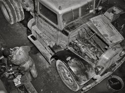 March 1943. "Baltimore, Maryland. Associated Transport Company trucking terminal. Truck service shop." Photo by John Vachon for the Office of War Information. View full size.
One of the OriginalsAutocar is one of the oldest American vehicle manufacturers, tracing its origins to 1897. The brand is still in business today. The company has a long list of significant achievements, including building the first commercially available motor truck in the US in 1899.
Clean minds, filthy handsIn 1943 if someone told you they'd just performed a "head job", they'd likely feel no need to blush. (Wink wink).  Associated was still relatively new when this pic was taken


Horton had  started out in 1930 in North Carolina.
Flat headValve placement is the giveaway.
Ignorant questionJust looking at the pic, how do we tell whether the engine's a Diesel?
Oil soakedNice placement of the "SHORPY" logo
It&#039;s called a valve jobAnd materials and designs have improved such that engine overhauls and valve jobs are pretty much a thing of the past.
[I see a ring job underway. - Dave]
Too Many Baltimore PistonsI agree with Dave that it looks like a ring job. Note the left-foreground ring atop its waxed paper wrapping, on top of the stack of what looks like four new ring boxes.
There are four used pistons (with connecting rods) on the workbench, but not four piston-less cylinders in the open engine.
So to what engine do these four piston assemblies belong?
Just a head gasketI see no indication yet that this was a valve or ring job.
All that has been removed is the head. Pistons and valves are in place as are parts that would need removal to gain sufficient access to remove pistons or valves.
This may just be a decarboning operation or they may have had leakage of exhaust into the coolant. 
Valve JobThere is a valve spring compressor on the last valve by the firewall. The pistons are probably from a different engine. It's not uncommon to have more than one job going at the same time. You got to wait for parts sometimes.
(The Gallery, Baltimore, Cars, Trucks, Buses, Gas Stations, John Vachon)