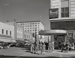 February 1943. "Albuquerque, New Mexico. Stores on West Central Avenue." An alternate view of this corner. Acetate negative by John Collier for the Office of War Information. View full size.
In just nine years ...Maybe the buildings haven't changed all that much, but maybe the world has gotten a bit more suspect ... or suspicious.
[Or thirsty. The fence is from a sidewalk cafe. - Dave]

+72Below is the same view from July of 2015.
Ye olde moderneMontgomery Ward, front and center in this photo, was one of a number of retailers that attempted to develop a look, erecting these pseudo-colonial boxes in small-to-mid-sized cities across the country. While hardly at the level of S.H. Kress' art deco masterpieces, they nonetheless got the job done,  even today being readily recognizable (at least when they haven't been covered over).

A different kind of shoppingThe Woolworth and Montgomery Ward buildings are still there, but of course the retailers are long gone.  Whomever Whoever remodeled the facade of the Ward's building, to make it look more Southwestern, didn't do it any favors.  The interesting brick buildings to the right of that, to the corner, are gone.  Street View shows the businesses located there now include a gentlemen's club and a tattoo parlor.
Yes, Dave, you caught me.  But you also reminded me of a joke that was a favorite of an English professor at UT Austin.
Knock-knock.
Who's there?
F@#k.
F@#k who?
F@#k Whom.
Haunted HiltonA nice article on the former Hilton, now the Andaluz Hotel, the ten-story building in the background:
https://hauntedhouses.com/new-mexico/hotel-andaluz/
Before/AfterMost of these "here's what it looks like now" photos seem so sterile. Sure, it may be cleaner, but there are so few people to be seen. No hustle and definitely no bustle.
(The Gallery, Albuquerque, John Collier, Stores & Markets, WW2)