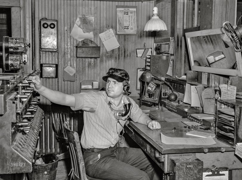 March 1943. "Waynoka, Oklahoma. An Atchison, Topeka and Santa Fe operator and telegrapher throwing one of the interlocking switches." Thirty years old and still playing with trains! Acetate negative by Jack Delano for the Office of War Information. View full size.