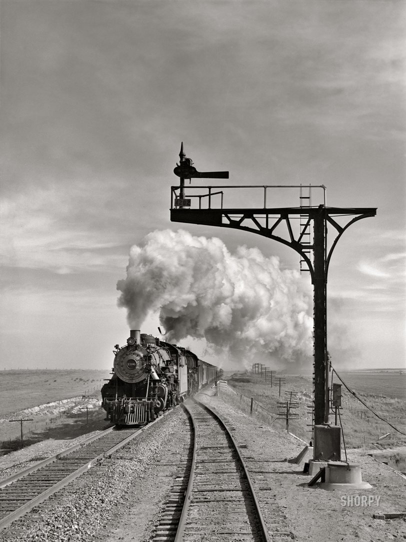 March 1943. "A westbound Atchison, Topeka and Santa Fe passenger train passing by a siding near the town of Hoover, Texas, enroute to Amarillo." Acetate negative by Jack Delano for the Office of War Information. View full size.
