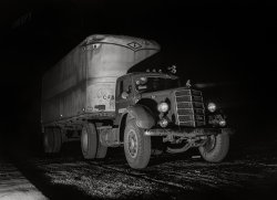 March 1943. "John Phillips enroute to Mobile, Alabama, on U.S. Highway 29 near Greenville, Alabama." Acetate negative by John Vachon for the Office of War Information.  View full size.
Bulldog MackJust look at those tires. I can imagine that truck grinding up the hills. The condition of the truck speaks to the skill this driver had to bring his load in safely.
GreasyThe kingpins in the front suspension need to be greased regularly. These are the pivots that allow the wheels to turn left and right. I was taught to wipe off the excess grease so it doesn’t look like this mess. You can clearly see where a mechanic wiped the grease from his fingers on the inner sidewall of the left front tire.
Could that be a Fruehauf trailer?In 1918 the Fruehauf Trailers Company was born​. With this semi-trailer invention and many other innovations, the Fruehauf story is an integral part of North American transportation history.
Where is It?I see a Mack Tractor and a Fruehauf trailer but where is the SHORPY watermark?
[Scroll up. - Dave]
Got it.  Nice job.
A Bogart filmReminds me of "They Drive By Night"
Mack EQThe first truck my father bought was a used EQ model Mack like the one in the photo. It was powered by a gas engine of about 450 cubic-inch displacement. He cut the sides off an open top freight trailer to make a flatbed and started hauling steel from the Allegheny Valley to western New York. Mostly Buffalo.
DriversI can see John Phillips, but where are Bogart and Raft?
Only one windshield wiperVery spartan equipped truck. Or was this to save rubber during the war years?
Workhorses of my childhoodFruehof and Trailmobile trailers were the most common makes seen in upstate NY in the '50s. Tractors were by Mack, White, Brockway, Autocar, Reo, Diamond T, GMC and others. Diesels of any make were rare; Kenworths and Peterbilts even more so.
RE: Only one windshield wiperI think it has a manual wiper.  I believe that the lever that you see just in front of the driver at that top of the windshield is for moving the wiper, so the driver has to use both hands to drive the truck without power steering, but also use his right to shift gears as well as power the wiper.
[Um, no. This is 1943, and the wiper is pneumatic. - Dave]
I had never heard of pneumatic powered wipers until now.  This site has some good pictures of what the driver would see of the mechanism.  Probably much better than the vacuum powered wipers, which would slow down under acceleration, or mechanical (used in the '42 GP and '43 GPA a friend of mine owns).  I learned something new!
Truck NoirWhat a photo!  That lighting slants right out of Double Indemnity.   (So that's how you do italics in these comments!  Dave, did you do the italics for me, or did I magically generate them, myself?)
Joad on the RoadThis reminds me of "The Grapes of Wrath." Tom Joad manages to hitch a ride, even though the sign on the windshield says "No Riders". He then proceeds to scare the crap out of the driver by saying that he just got out of prison for homicide.
(The Gallery, Cars, Trucks, Buses, John Vachon, Mobile)