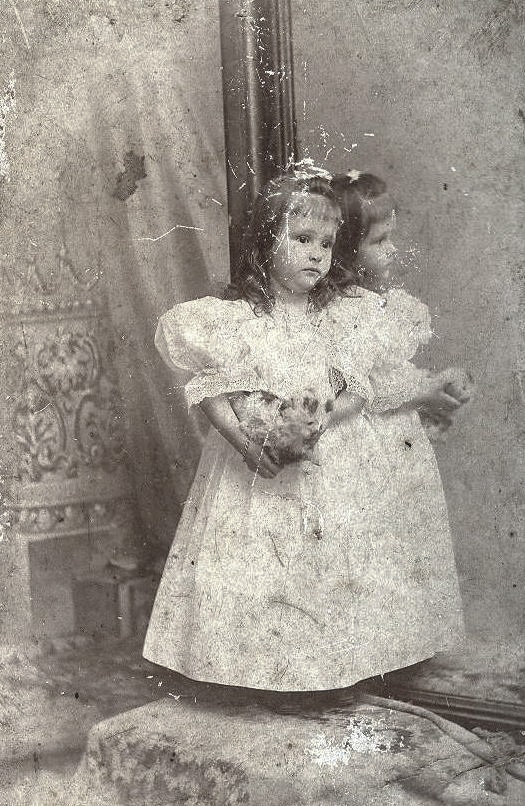 There is quite a story behind this picture. This was my great-grandmother's cousin. The picture was taken in 1896 in New Orleans, when Amy was not yet 3 (her exact age and name are on the back). It was taken in a photographer's studio near the old French Opera House. 
Anyway, she died about 2 years later along with her grandmother (my great x 3 grandmother) and her mother on the shipwreck La Bourgogne. They were going to get my great-grandmother from Switzerland, where she was staying with her other, Swiss grandmother and bring her back to New Orleans. 
After the deaths of her New Orleans grandmother, a cousin, and an aunt, my great x 2s were afraid to bring my great-grandmother home, so she spent most of her childhood in Switzerland. She, and later her daughter-in-law (my grandmother) saved this picture of her lost cousin. The Aldige family tomb in Metairie Lawn has a statue of two angels weeping on a sinking ship on it and has the inscription "In memory of mother, sister, and niece lost at sea on the steamship La Bourgogne July 4, 1898." View full size.
