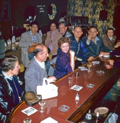 Mid-50s bar scene, possibly in the Los Angeles area. From one half of a stereo slide I found in a thrift store. If the resolution was just a bit higher we could get a name off those napkins. View full size.
Napkin nameLooks like "Surf and Sand" to me.
1952-53 Seeburg Model BThe date can be determined by the joint's juke.  The hair and clothing styles suggest the same.
Cigarette Guy has an admirer.
Marlboro CountryThe pack of Marlboros in the "flip-top box" dates it to 1954, at the earliest. From this site:
"The 1950s saw the introduction of the hinge-lid pack, which was originally invented and patented by Walter’s son, Desmond Molins, in 1937. The hinge-lid pack was a major step forward from the previous soft packs, which allowed cigarettes to be damaged, and was used by Philip Morris in 1954 to relaunch the Marlboro brand: it was instantly successful and Marlboro sales increased 50 fold."
(ShorpyBlog, Member Gallery)