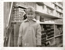 About 1961 in the camera store. The salesman is showing Dad the cutting edge of Polaroid Technology. The swipe marks are now visible across the bottom of the photo. Deanna Lowe is the beautiful subject ... previously afraid of cameras! View full size.