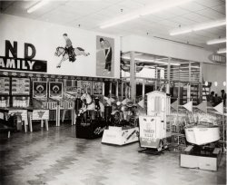 An old 8x10 print of a typical department or discount store in the late '50s or early '60s. The amusement area is near the store entrance to the delight of the kids (and parents). Baseball machines and bowlers were popular back then as well as the kiddie rides. A Bally Mfg. price list found online dates the machines to 1958. View full size.
AmusementsHeck with the machines -- there are donuts back there!
(ShorpyBlog, Member Gallery)