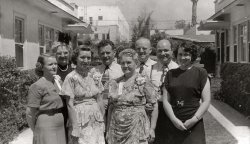 From the same spot with the group of kids, now the adults. Included in the cast are my grandparents, one of my great aunts, a great uncle, my great-grandparents, and a couple others I don't recognize. Taken around 1946. View full size.
&#039;40s fashionsYou can see that prosperity has come back to these families. It wouldn't surprise me if these ladies worked in the factories, building tanks, planes,etc.  They have the money to buy these lovely dresses.  Let us not forget the short, WILD ties the men are wearing.  Oh, bring back these fashions!
The  Winnersof some sort of contest by the ribbons on their chests, plus the corsages of varying sizes.  Maybe it was Mother's Day.  I would guess that this picture was taken in Los Angeles in the ever abundant court-styled bungalows. Nice photo. 
(ShorpyBlog, Member Gallery)