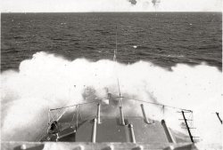 This photo was likely taken in 1950. The cruiser HMCS Ontario was originally HMS Minotaur before being transferred to the Canadian Navy in May 1945. After the war she became a training ship with the Canadian Navy.  This photo was clearly taken on or near the bridge of the ship. The caption written on the photo has the name "Antigonish" crossed out and replaced with "Ontario." Since HMCS Antigonish was a single gun River Class frigate while HMCS Ontario mounted nine 6" guns in three turrets, it suggests that the person who wrote the caption wasn't in the Navy, though the photographer clearly was.