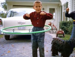 This is me in the summer of 1958 in Bedford Quebec, during that year's Hula Hoop craze. As you can see, Mom sure did dress me in a weird way -- buttoned-up collar, full cuffs and elastic band pants? Our cocker spaniel Cindy is in the background. View full size.
Hair raisingIt took 50+ years but that front flip hair do is in style today
Hula Hoops and AlleysIn September of 1958 I was a grade 6 student at the old Brown School off of Avenue Road in Toronto, Ontario. There were separate girls and boys entrances, and the unpaved, fenced school yard had an imaginary line down the middle. At recess, the girl's side was a forest of spinning hula hoops, and the boy's side was a sea of marble games, or "alleys" as we called them. A deep purple Crown Royal Whiskey cloth bag held the marbles. No boy dared to use a hula hoop, and no girl played with marbles. And no one crossed that boundary! To signal the end of recess, the back door of the school was opened and a teacher rang a large brass hand bell. Back in the classroom, we dipped our pens in inkwells and filled our workbooks. Misbehaviour was dealt with quickly out in the hall with a leather strap. 
Nice 56 Chevy"Say, how do you put gas in this thing?"
Said by me as a kid working as a pump jockey, to customer with wry grin.  He then showed me how to flip the tail light open to access the filler tube.
More than one 50s iconThe '56 Chevy, hula-hoop, little red (probably metal) wagon and of course the child's attire &amp; hairdo.  Many good memories.
The smileI think that there is a deep and weird psychological quirk in humans that produces that smile from a round hoop of plastic; "Hey! everybody!!!!! Look at me! I'm doing it!!!!!   
&quot;Cindy&quot;must have been a popular name for black cocker spaniels in the 1950s. My Cindy's full name was Cinders Ebony Night.
Born in Montreal 1944At 16 yrs old I got my drivers licence and sped away in the family car .. a 1956 Chev 210 4dr stick shift.
Dipped the girls pigtails in the inkwell. Got retrained to write right-handed instead of left. I know the strap well.
Yo-yos and aggies were the recess activities.
I had a black dog named "cinder".
Loved to watch the girls practice their Hula Hoops !
Great photo
Right there with you!Same year,  probably same age (or close to it), I was 6 and we were stationed at the time not all that far from you at RCAF Station Goose Bay, Labrador.  My sister and I both had hula hoops and loved them.   What great exercise too,  when  you think about it.  :)
Properly-dressed Canadian boyNuthin' weird about it.
Weird? What weird?I would kill for that shirt! Size XL, of course. (And full cuffs would be alright, too.)
You know..for kids!
That smileYour smile is positively too cute.
Hula Hoop Contest!Long ago, in my hometown East Aurora NY, the Theater would have different contests between Saturday Double-Features. In 1958, I won a Hula-Hoop Contest...I was able to keep it going the longest.
The Secret: It's all in the hips!
PistereeDuring these years in late 1950s Bedford, a popular game played at the schoolyard was called "Pisteree". It was an indigenous game to the Quebec Eastern Townships in the '50s, and went like this...
In the gravel playground of the school, you cut a groove with a stick, about six inches long and three inches deep. Then cut a broomstick at four inches and three feet, making for the key instruments of play. Overlap the small stick over the groove, hit it with the long stick to twirl it in the air, then bat it to the outfield. Count points by "walking" the short stick to where play stopped, in increments of "five", as in "five, ten, fifteen, twenty,....". We played that for years between 1956 and 1961.
Is there any history out there of this game?
The Hollywood BurrA late 50's, early 60's (mild) sign of rebellion for the pre-teen set.  At least it was where I grew up in the Midwest.
They could&#039;ve had a V-8In its second year availability, but decided to stick with the tried and true Blue Flame Six as no "V" is present under the blue bow-tie medallion.
They cost a big $1In the exact same year I walked down the street in Rahway ,New Jersey with my dollar in my hand to buy a brand new, bight yellow hula hoop. I think it took me years to figure out how to really use it. 
(ShorpyBlog, Member Gallery)