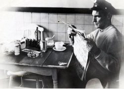 This is my stepfather, taken around 1960. He worked for the Newark Police Department, 4th precinct. I am curious, can anyone identify the object behind his ashtray? I know that a friend of his (maybe the one who took the photo) was a bus driver, that would account for the money changer on the table. I see a loaf of bread, sugar, a matchbook... View full size.

