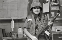 My mother in Vietnam, 1969.  Her hospital was on alert for one reason or another, and she decided to have a picture taken with a soldier's M1 carbine.  As a nurse, she of course didn't have her own personal weapon. View full size.
A brave galYhere were plenty of women that served in Vietnam, in capacities such as this nurse. They put themselves in danger too, some of them were killed over there.  
We were so youngThis photo of your mother is powerful. It penetrates 40 years of life and memories and what might have been. Your mom was a year or two older than me in 1969, after all, she graduated nursing school, but we had the look of babies.
Did this all really happen?
Did we really go to that place?
And now when I buy shirts
I find little tags telling me
Made in Vietnam
and sometimes I cry.
God Bless Herand all Vietnam vets who won all the battles fighting the good fight.
An Khe 1969I served with the 1st Cav (AM) and was stationed in An Khe Feb 1969 - May 1969.  I remember one night when the VC were inside the perimeter and tossing "satchel charges" in the base hospital and MP areas.  Don't remember much else about An Khe.  I moved to Bien Hoa in June and came back home in February, 1970.
(ShorpyBlog, Member Gallery)