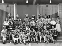 Looks like Western Day at a school in Phoenix, Arizona with the Bill Williams Mountain Men. On the back is stamped "Earl's Camera Shop, 1616 E. Camelback, Phoenix, Ariz. 85016, 3/13/64." 8x10 from an estate sale in an older neighborhood in Phoenix. Any Shorpyites recognize the record album the girl in the upper left is holding? I can make out Sammy Davis Jr. and Ray Charles. Check out the outfit the boy (4th from left, front row) is wearing. View full size.
For the RecordThe album shows the back cover of a Design "Spotlight Series" LP. The titles ("Spotlight on Ray Charles," etc.) came in mono and stereo. Click to enlarge.

Album frontWe had an album with this on the back cover, but I just can't remember what was on the front.
Hairy SituationFor whatever reason, every single adult male in the photo has facial hair, and I'll bet 10c it was real then, not some fake whiskers.
Doesn't appear any of the women have much facial hair, but I'm still inspecting.
And, we'll also wager the men wearing fox heads as part of their caps got them from real foxes, too, not some plastic look-alike that we'd wear today.
Very interesting picture.
Visiting the KidsThe March 4, 1964 "Arizona Republic" (10 days before the picture's date) tells us that the BWMM were just then taking off for their horseback journey to Phoenix in unusually cold weather, and that a destination for March 14th was to "meet the children in Good Samaritan Hospital" -- the previous day's activity being likewise at Children's Hospital.
KidsYes, I like the outfit on the 'class clown' you mentioned, lower left. I also love the expression on the lil cow poke just to the right of that record album. There's a devilish glint in them thar eyes!
The cigar chompin mountain man looks a little like Alan Hale. There's a boy, mid right side that reminds me of David Nelson. And I just love the cowboy accountant seated in front of him.
Real FurPretty much all the re-enactors I know are very particular about authenticity. Guys portraying mountain men would most certainly have real beards, and genuine fur hats, and real buckskin, etc. There's a ton of peer pressure for everything to be authentic to the period being portrayed. My son bought a genuine fox head pelt at the Fort Massac encampment near Metropolis, Illinois. He loved it, and as a bonus (in his mind) it creeped his sisters out.
Doggone it!I had my mind all made up to be an astronaut, but now I'm not sure I wouldn't rather be a mountain man!
(ShorpyBlog, Member Gallery)