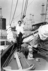 Another from my grandparents' photo album. I don't know who that is in the picture. I think this is in San Pedro, definitely around the time when oil derricks could be found all around Los Angeles. View full size.