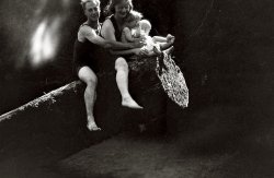 This is from an old scratched up negative, but I think it's beautiful. This photo was taken right about 1927, and my husband insists that it was taken by the man on the log, his grandfather Tom Boothby. View full size.
Love ItI love this photo.  Lots of love, warmth &amp; happiness.  If you Photoshopped modern bathing suits on them, it could have been taken yesterday.
Charmed and confusedI love this family, and I love the light and dark here.  But I'm confused as to what's happening.  Is this really some type of ride?  The bathing suits would seem to suggest that, but the people appear to be balanced precariously, if it is, and at least one of the kids looks pretty young for anything too wild.  Or are they just sitting on a log by a river?  And how could the photograph by taken by the man in the photograph?
I feel slow for asking, but curiosity has overcome my embarrassment.
Re: ConfusedRiding the log and babies: It's an old story, honey.
What joy!But if any photo is begging to be Farked, this one surely is.
(ShorpyBlog, Member Gallery)