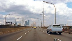 The last of three submissions on a trip to Toronto on the QEW, Labour Day 1979. Now I'm on the Gardiner Expressway, an elevated waterfront highway opened in the late 1950s. Downtown Toronto and the CN Tower are center of view, a scene that looks dramatically changed from this Gardiner view today. View full size.
Toronto buildingsThe white tower left of centre, First Canadian Place, at Bay and King, is Canada's tallest building (72 floors), completed in 1975.  Originally clad in white Carrara marble, the 45,000 stone panels were replaced with glass in 2012 after a slab of marble fell off the building in 2007.  The black towers are part of the Toronto-Dominion Centre, designed by Mies van der Rohe, with the first building in the complex completed in 1967.  The two golden towers on the right are the Royal Bank Plaza, finished in 1979, and the glass used to clad them was colored with 2,500 ounces of gold.  When the sun hits those towers at certain angles during the day, the effect is both magnificent and blinding.  The old green-capped building just in front of the Royal Bank is the Royal York Hotel, only 28 floors high, but at the time of its completion in 1929 the tallest building in the British Empire.  The CN Tower, on the far right, was the world's tallest free-standing structure when it was completed in 1976 and held the title until 2010.
The Inglis sign, by the way, was there until July 2014.  Installed in 1975 on Strachan Avenue on the site of the appliance manufacturer (since incorporated into Whirlpool), it was no longer visible to the Gardiner Expressway, having become lost in a forest of condo towers.  Along its lower edge, the sign displayed various "inspirational" messages to motorists, such as "Live while you are alive" and "To reach the fruit, one must go out on a limb" and "The greatest remedy for anger is delay."
(ShorpyBlog, Member Gallery)