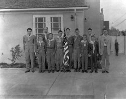 My father Gary stand 2nd from the right in the front row back when he was a Boy Scout. His father Frank is 2nd from right in the back row and seems to be quite thrilled to be a Scout leader. I'm not sure what the kid at the back gate is doing. Taken late 1940s in Los Angeles. View full size.