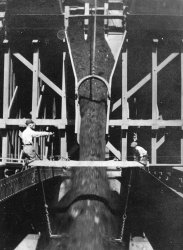 From an old family photo album from the turn-of-the-century. They're loading something (looks like coal or ore to me) into the hold of a ship.