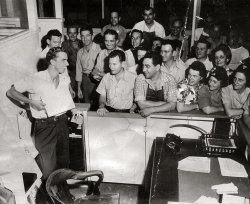 I honestly am not sure what is going on in the picture. My grandpa Frank is the one standing in front of the office door. It seems like a posed picture too, but what the man on the left is showing, I don't know. But it seems like everyone is having fun. Taken around the mid 1940's. View full size.