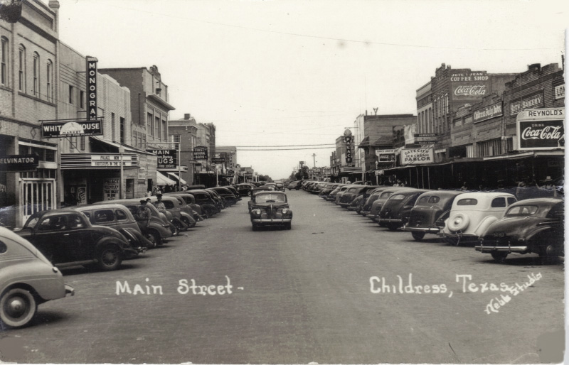 A vibrant main street in Childress, Texas, 1941. The date was determined by looking at the movie titles on the theater on the left. "Footsteps in the Dark" is on the marquee and  "That Night in Rio" is on a poster. Both were released in the spring of 1941. View full size.
